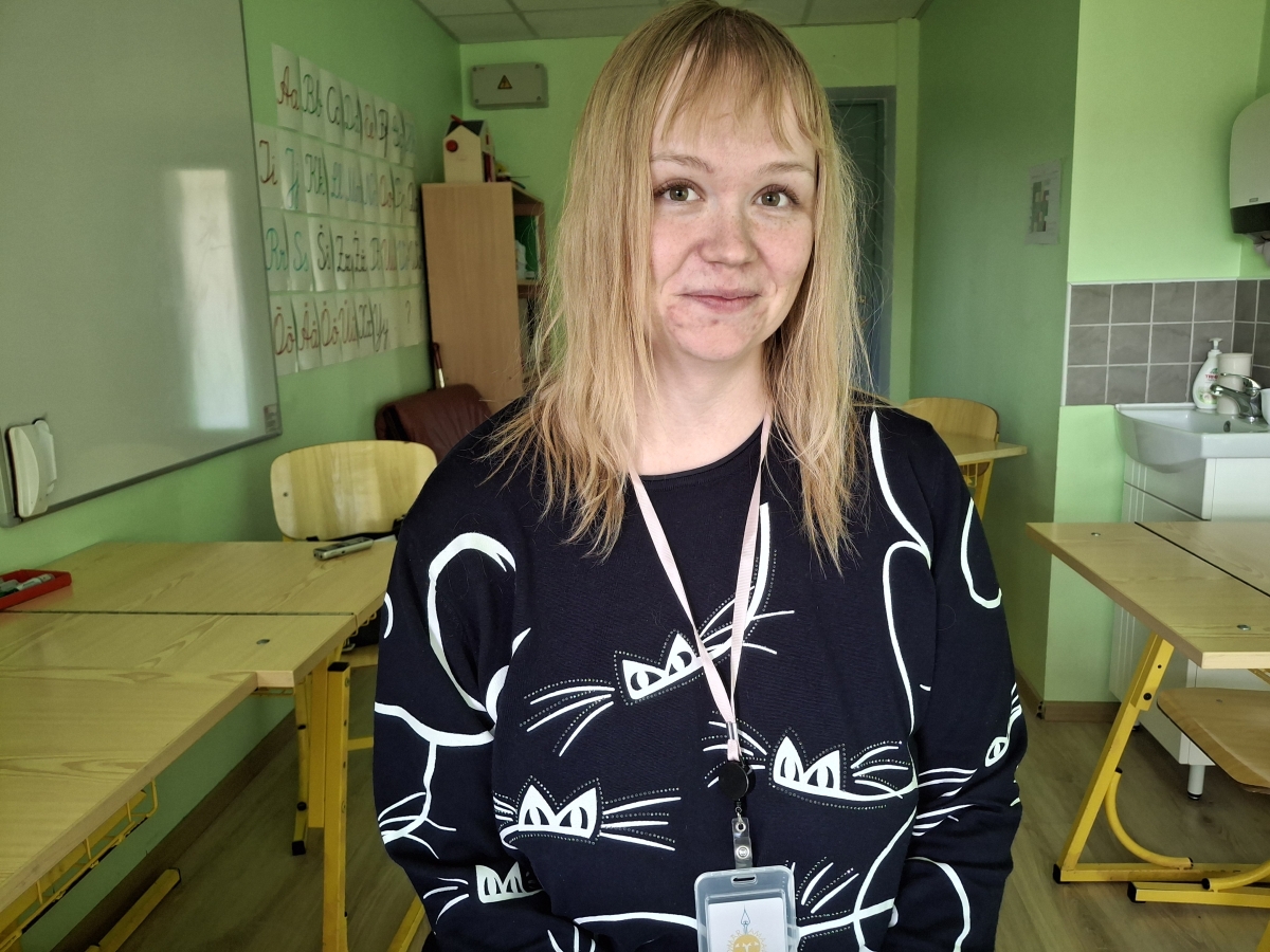 Roheliste seintega klassiruumis on heledapäine noor õpetaja.